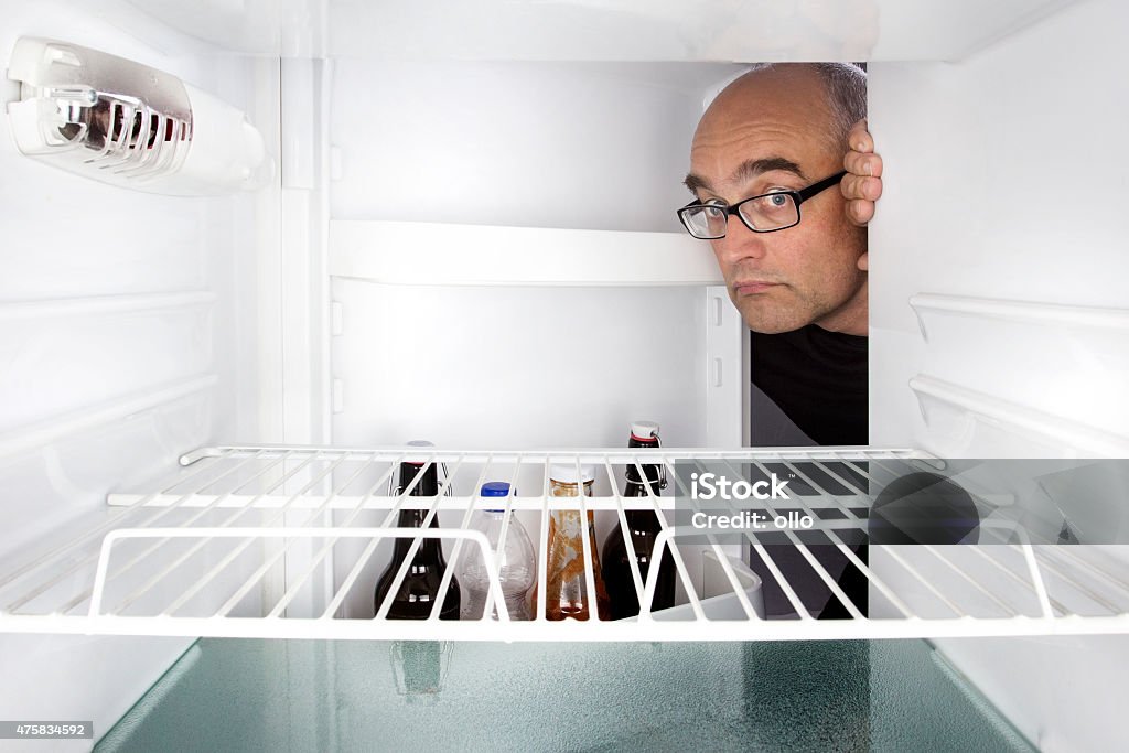 Medio hombre anciano s'abre un refrigerador pequeño - Foto de stock de Frigorífico libre de derechos