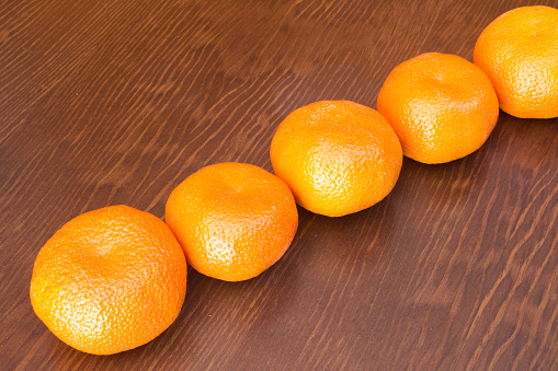 fresh bunch of mandarines in a wooden background