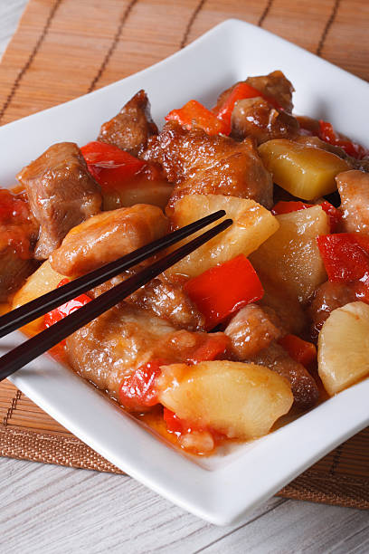 istock Asian pork meat with pineapple on a plate close-up. Vertical 475836288