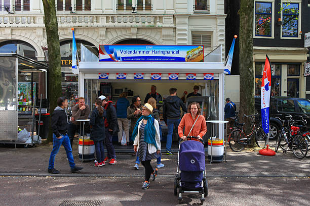 Amsterdam, The Netherlands - May 15, 2015: Locals and tourist at one of Amsterdam's famous Herring street shop. with people.
