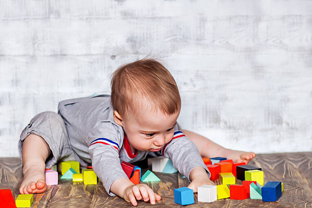 istock Cute smiling baby boy with colorful wooden bricks 475842388