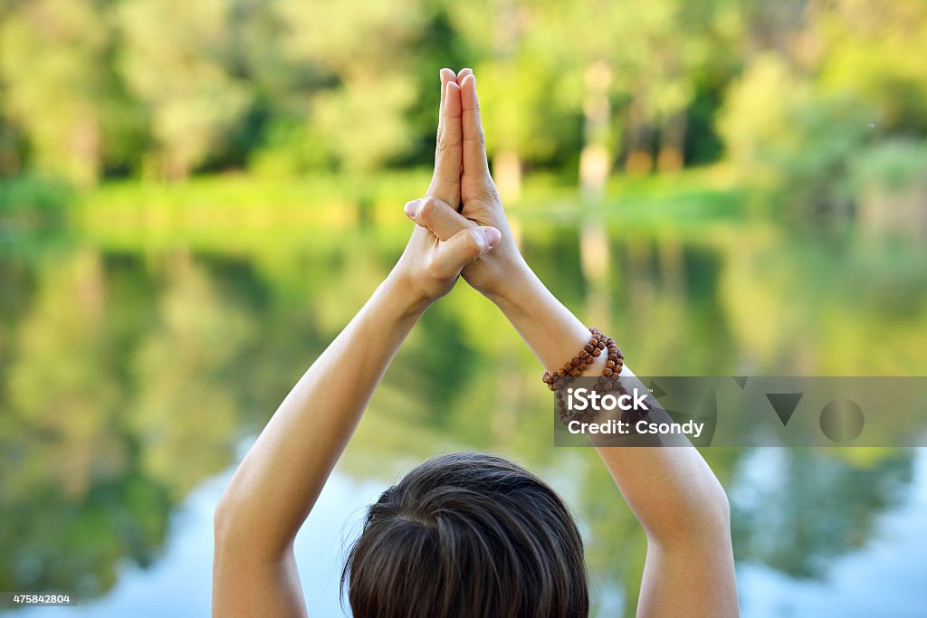 Yoga pose Young woman practising yoga outdoors, her hands in praying pose. 2015 Stock Photo