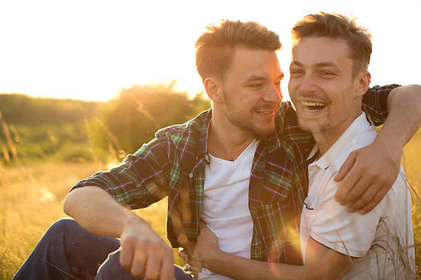istock Young gay couple in a meadow. 475842832