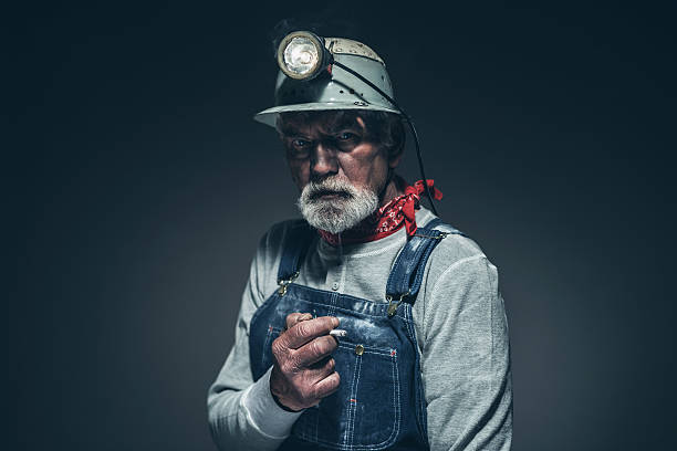 istock Serious Adult Male Mining Worker with Smoke 475843200
