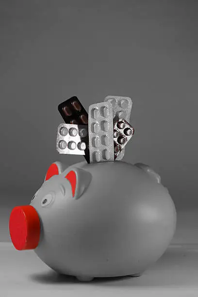 Pills in Blister packs with a Piggy Bank, Concept