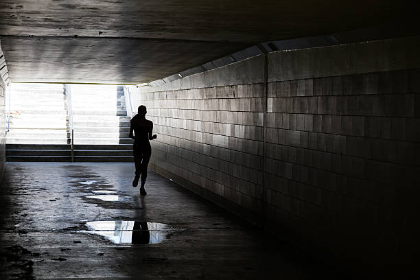 istock Female running in through a tunnel 475850118