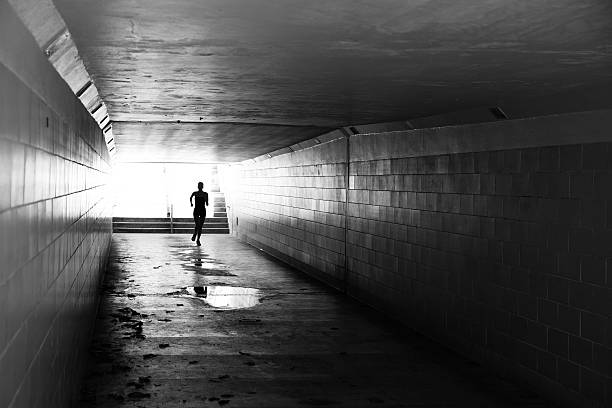 istock Female running in through a tunnel 475850120