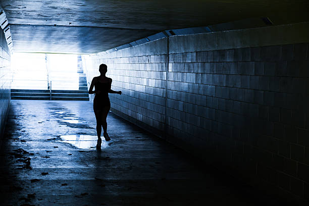 istock Female running in through a tunnel 475850124