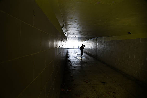 istock Female running in through a tunnel 475850330