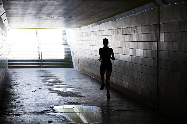 istock Female running in through a tunnel 475850334