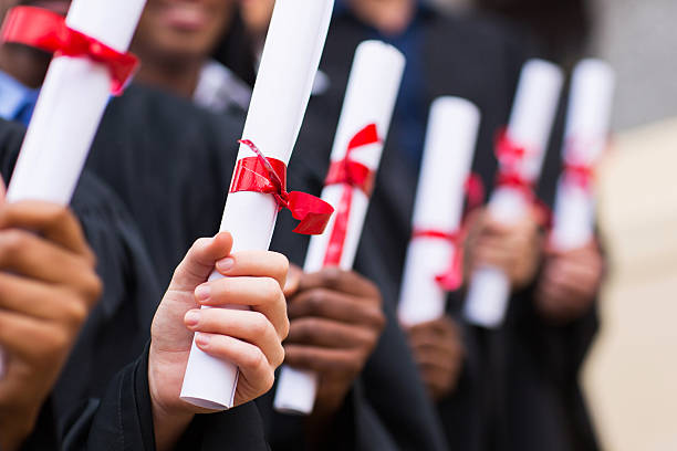 группа выпускников, держа диплом - graduation adult student mortar board student стоковые фото и изображения