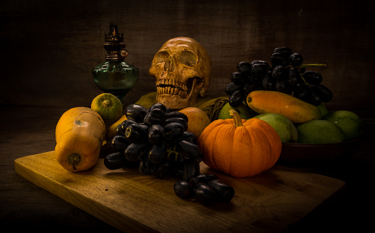 still life with fruits and skull on grunge background