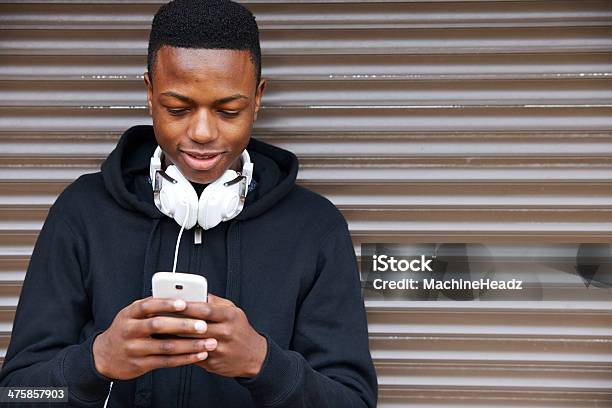 Teenage Boy Listening To Music And Using Phone Stock Photo - Download Image Now - Teenager, Telephone, African Ethnicity