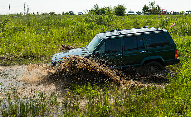 オフロード自動車ブランドのジープ cherokee overcomes 、ピットの泥 - off road vehicle 4x4 jeep mud ストックフォトと画像