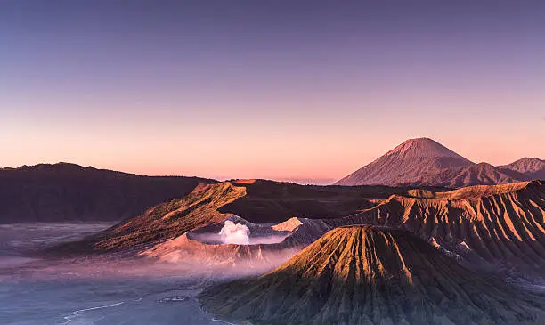 Morning view of the Bromo caldeira in East Java in Indonesia. The volcanic formation of a few volcanoes, with the famous volcano Bromo and the Semeru volcano in the background attract everyday large crowds of visitors on the mountain top. The photograph was taken at early sunrise, 5AM.