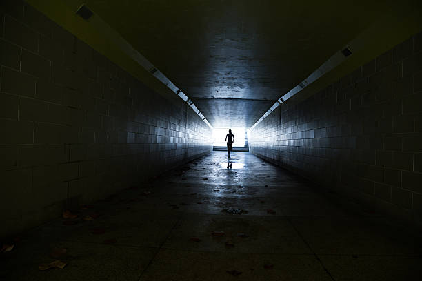 istock Female running in through a tunnel 475870432