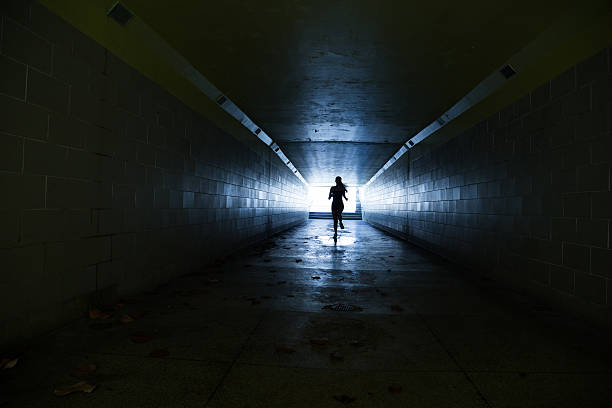 istock Female running in through a tunnel 475870436
