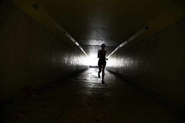 istock Female running in through a tunnel 475870440