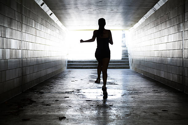 istock Female running in through a tunnel 475870444