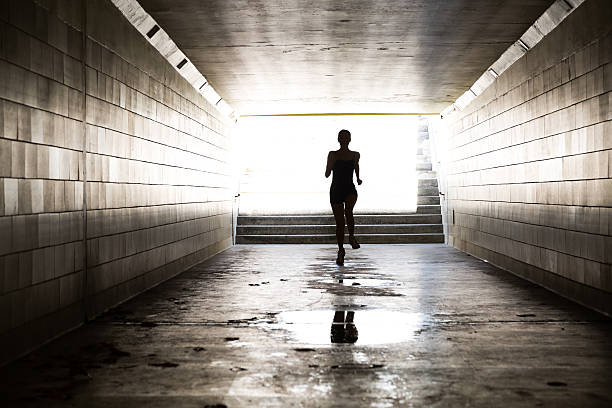 istock Female running in through a tunnel 475870454