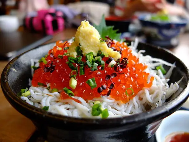It is the Japanese dish that salmon roe and whitebait were colored on the rice. It is called "Shirasu Ikura Don". I photographed this in Enoshima island of Japan.