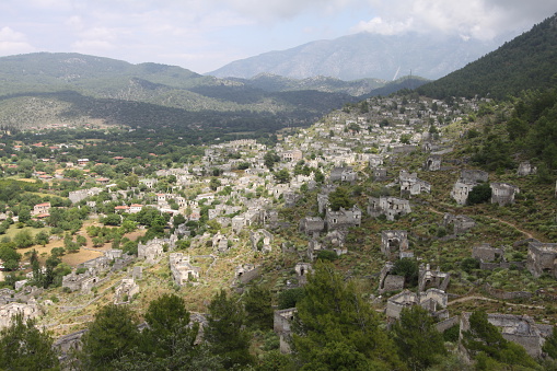 The empty and ruined buildings of Kaya Koy stand on the side of a hill in Turkey.