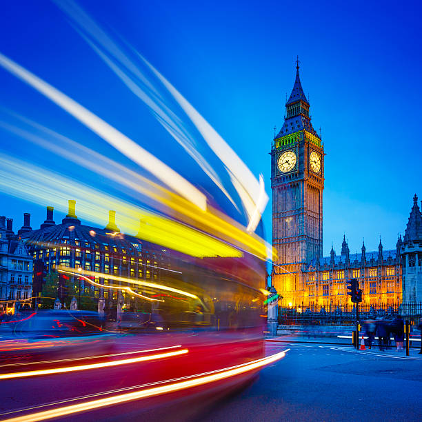 Traffic light trails near Big Ben and the Houses of Parliament in background at dusk, Westminster, London, UK. 