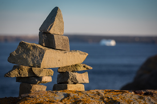 Pile of stones and rocks forming an Inukshuk landmark along the Newfoundland Coast on the Atlantic Ocean.