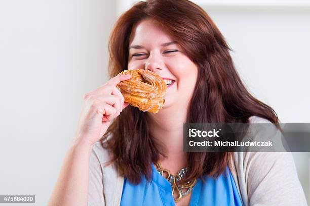 Plump And Happy Woman Eating Donuts At The Table Stock Photo - Download Image Now - 2015, Adult, Adults Only