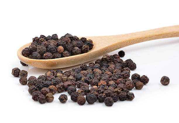 istock Black pepper in wooden spoon on white background. 475884216