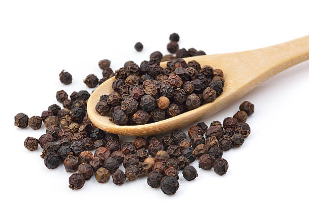 istock Black pepper in wooden spoon on white background. 475884378