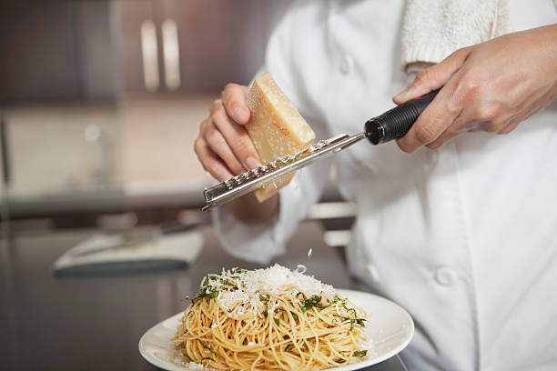 chef reticolo di formaggio a pasta in cucina - grater foto e immagini stock