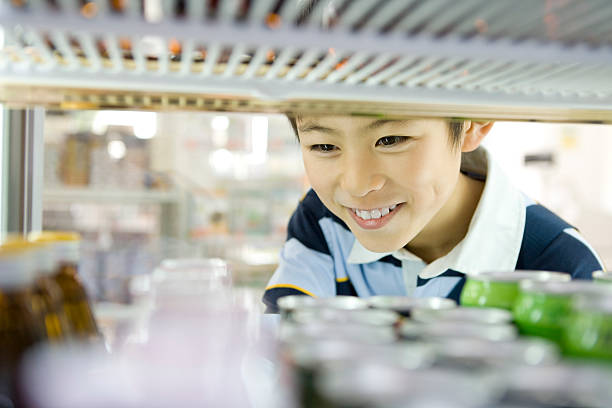 Boy choosing drink at convenience store stock photo
