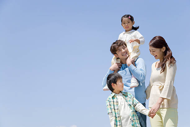青空と家族 - two generation family 写真 ストックフォトと画像