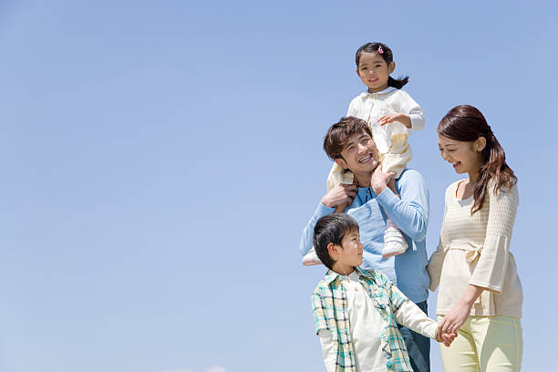 青空と家族 - four people ストックフォトと画像