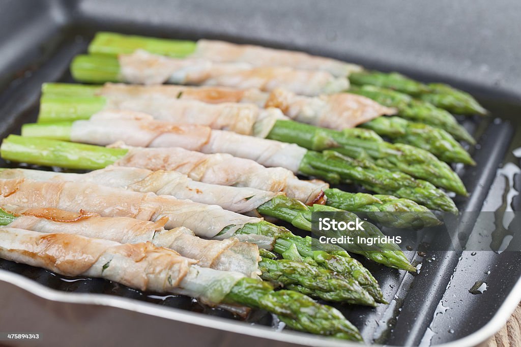 Grilled prosciutto wrapped asparagus Prosciutto wrapped green asparagus on a grilling pan Appetizer Stock Photo