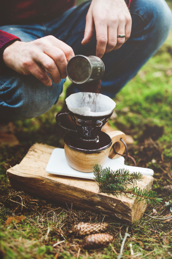 Man making coffee in the woods on camp