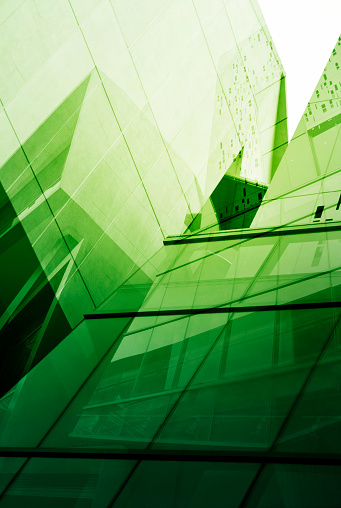 Glass of modern tower for business background, green tone