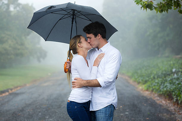 istock couple kissing under an umbrella 475898814