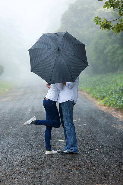 istock young couple hiding behind the umbrella 475900814