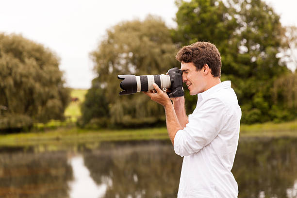 istock young man taking photos outdoors 475903600