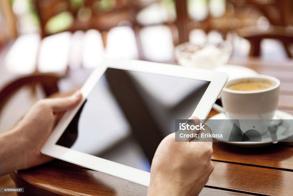 Businessman uses digital tablet Businessman uses digital tablet and drink coffee Digital Tablet Stock Photo