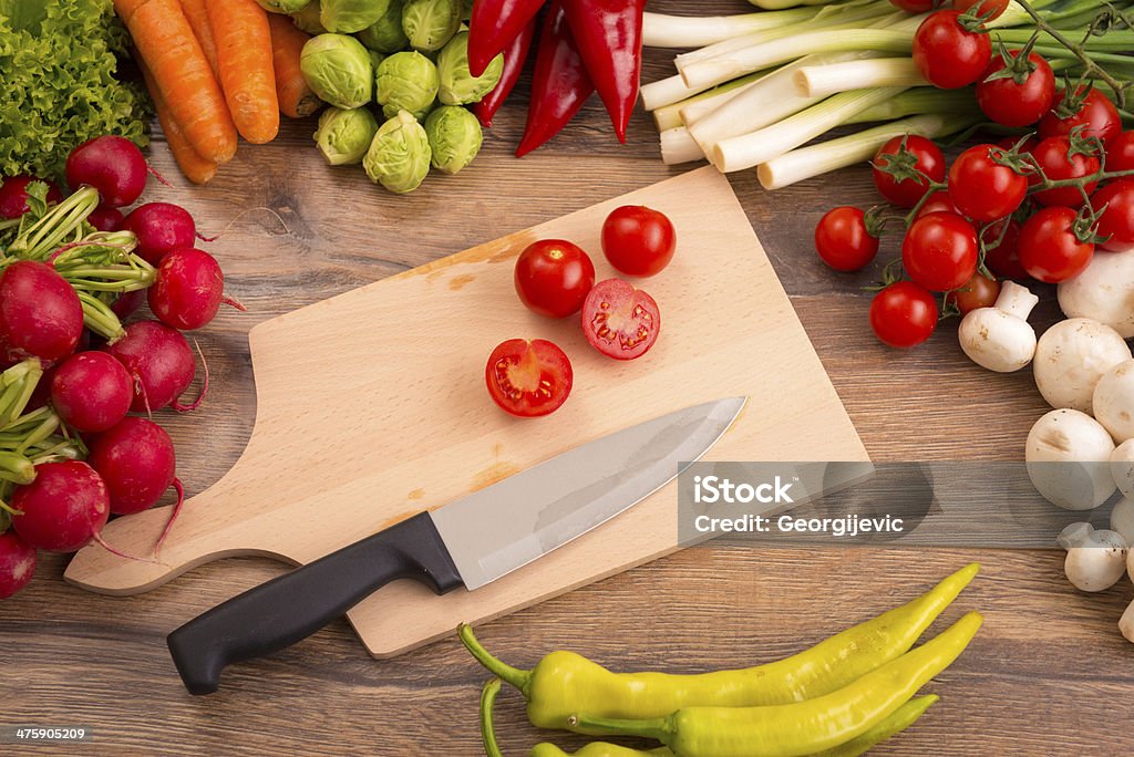 Vegetables Raw vegetables, knife and kitchen board on the table. Abundance Stock Photo