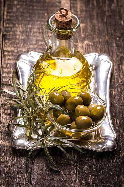 istock Olive oil and olives on wooden table 475908524