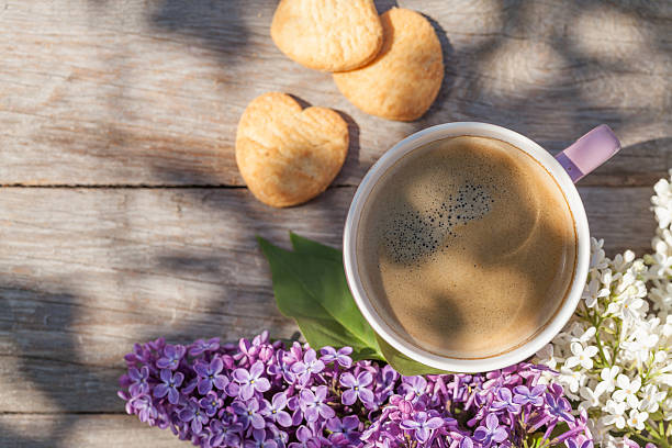 istock Coffee cup and colorful lilac flowers on garden table 475912604