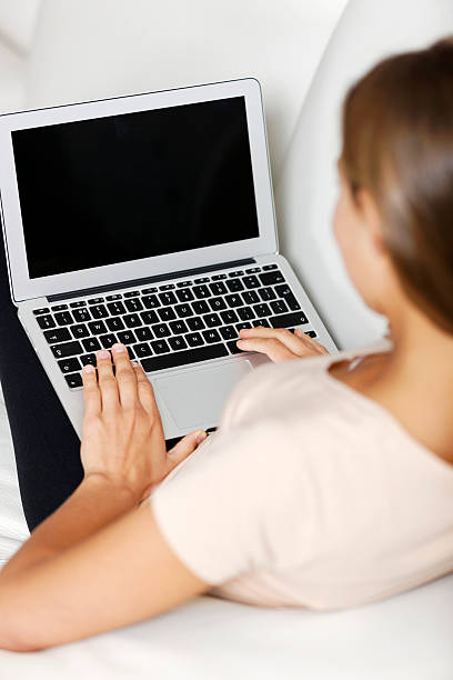 istock Woman using laptop at home 475913773