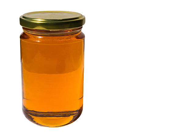 istock Glass jar of honey on white 475915198