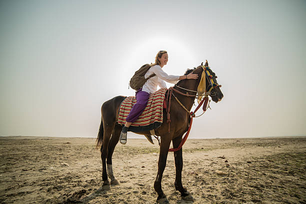istock Young woman riding horse 475915593