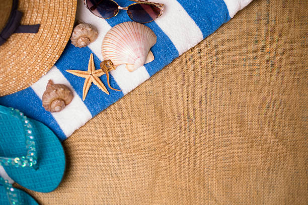 istock Summer vacation scene. Seashells, sunglasses, hat on beach towel. 475923830