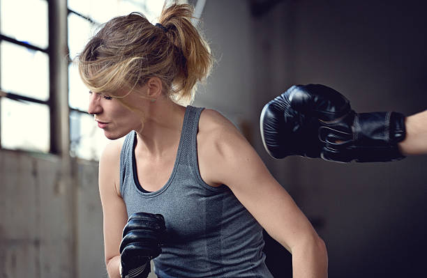 istock Female boxer sparring with her trainer 475923934